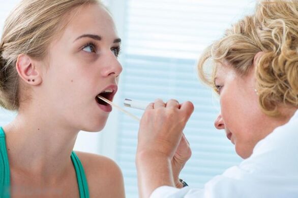 הרופא בודק את חלל הפה לאיתור פפילומות